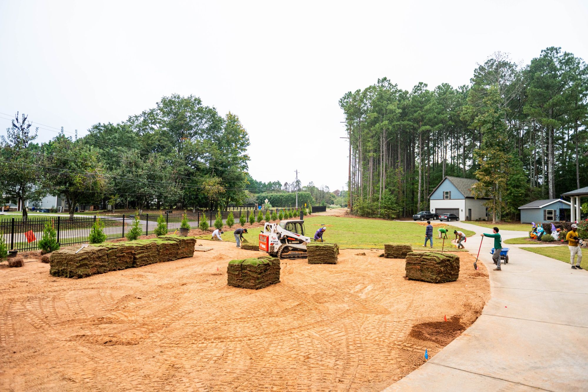 Green Wave crew laying sod across a large front lawn